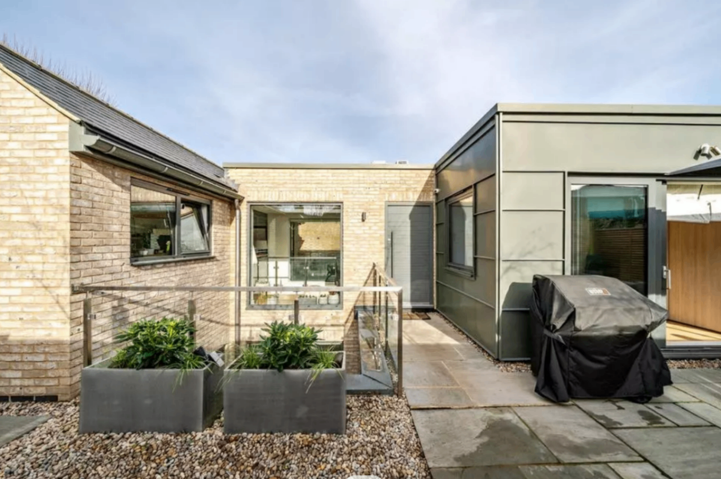 New build buff brick courtyard with glass balustrade and contemporary landscaping